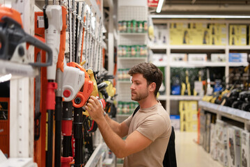 Male choosing trimmer from gardening tools