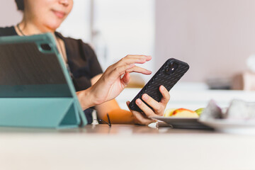 Woman work at home and using smart phone and notepad computer.