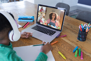 Canvas Print - African american boy using laptop for video call, with diverse high school pupils on screen