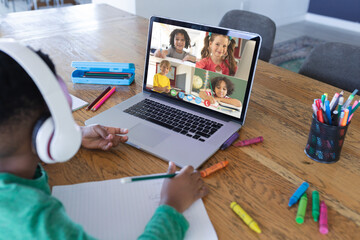 Sticker - African american boy using laptop for video call, with diverse elementary school pupils on screen