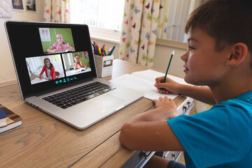 Sticker - Caucasian boy using laptop for video call, with smiling diverse elementary school pupils on screen