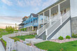 Three large houses with white picket fence and verandas at the entrance in Daybreak, Utah