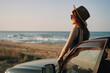 Leinwandbild Motiv pretty woman in sunglasses near the car on the beach travel lifestyle