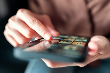 Online movie stream with mobile phone. hand of woman choosing film on smartphone with imaginary video player service.