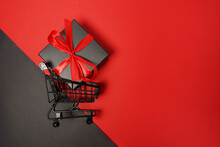 Black Friday Sale Shopping Cart With Gift Box On Red Background