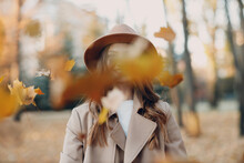 Young Woman Model In Autumn Park Throws Up Yellow Foliage Maple Leaves. Fall Season Fashion