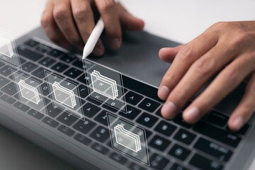 Leinwandbilder - Paperless workplace concept based on e-documents. On a virtual screen, a businessman works on a laptop computer keyboard with electronic document icons.