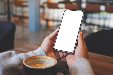 Mockup image of hands holding mobile phone with blank desktop screen