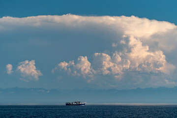 Wall Mural - Ship on Lake Baikal under cumulus clouds