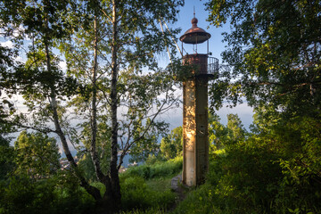 Wall Mural - Old lighthouse among trees on the shore of Lake Baikal