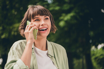 Poster - Photo of shiny funny young lady dressed green shirt walking communicating modern gadget smiling outdoors urban park