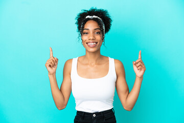 Sticker - Young latin woman isolated on blue background pointing up a great idea