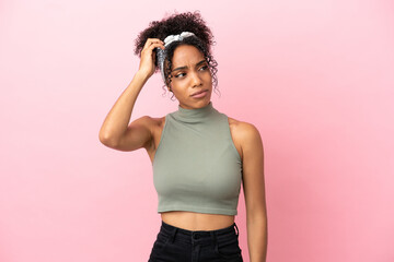 Wall Mural - Young latin woman isolated on pink background having doubts while scratching head