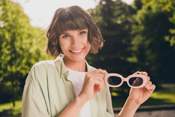 Sticker - Photo portrait young girl with bob hair keeping sunglass smiling overjoyed walking on city streets