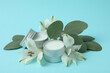 Eco lip balm and flowers on blue background