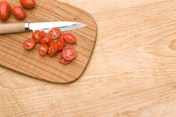 Sticker - datterini tomatoes and knife on a wooden chopping board on a rustic wooden background