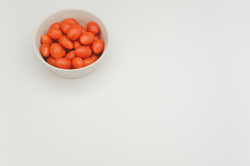 Poster - datterini tomatoes in a decorated stoneware bowl on a white background