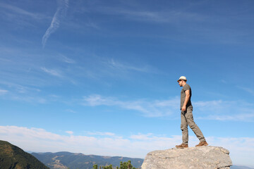 Canvas Print - Man enjoying picturesque view on cliff in mountains. Space for text