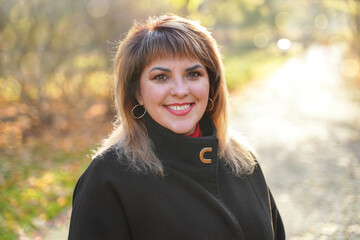 Portrait of happy smiling adult woman outdoors. Middle-aged cute person