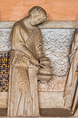 Sticker - Close-up on marble religious statue carved in a monastery wall representing a monk carrying a pan