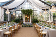 Wedding banquet hall in the greenhouse, tables are set, decorated with fresh flowers, candles, crystal chandeliers. Soft selective focus.