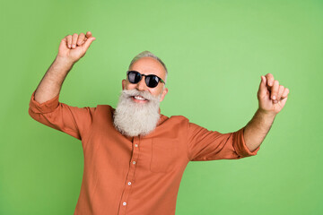 Poster - Portrait of attractive cheerful grey-haired man dancing having fun rest resort isolated over green color background