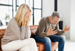 © Face Stock - Home abuse concept. Depressed mid-aged woman sits on the couch and crying, an irritated and angry mature man is screaming on the background. A couple is arguing at home