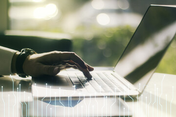 Double exposure of circuit hologram and hands typing on laptop on background. Research and development hardware concept