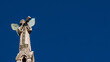 Cherub Angel blowing trumpet. A medieval 13th century statue a the top of St Michael Church in Lucca (with copy space)