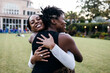 © Creative Flame - Black women sisterhood, smiling outdoors, embracing, hugging