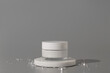 White unbranded cosmetic cream jar standing on white podium. Skin care product presentation on the gray background with small crystals. Trendy mockup. Skincare, beauty and spa.