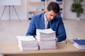 Young male employee unhappy with excessive work in the office