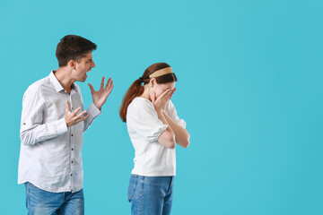 Poster - Young man shouting at his wife on blue background