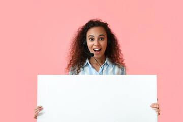 Poster - Surprised African-American consultant of call center with blank poster on pink background