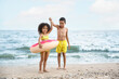 © Pixel-Shot - African-American children with inflatable ring on sea beach