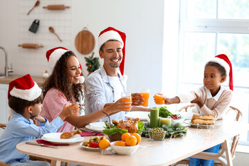 Wall Mural - Happy family drinking juice in kitchen on Christmas eve