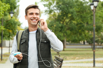 Poster - Young man with phone and power bank outdoors