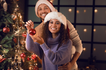 Wall Mural - Happy couple decorating Christmas tree at home