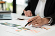 © PaeGAG - Businessman pen pointing turnover with graph chart report and use laptop computer for analysis data