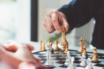 businessman playing chess on board in office, strategy and competition concept