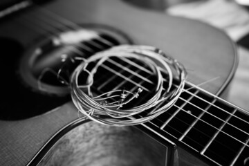 Artistic black and white old guitar string on an acoustic guitar