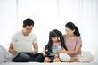© chokniti - Asian children learning from home, homework learning with father and mother together in daughter family by laptop technology people, happy girl in online education lifestyle