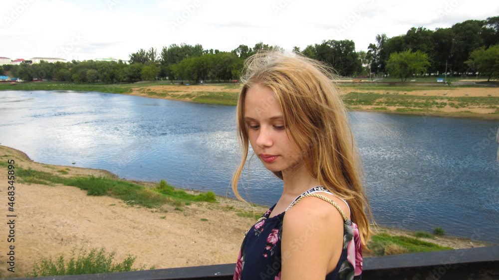 Young girl on the bridge by the blue lake Stock Photo | Adobe Stock