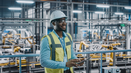 Poster - Happy African American Car Factory Engineer in High Visibility Vest Using Tablet Computer. Automotive Industrial Facility Working on Vehicle Production on Automated Technology Assembly Plant.