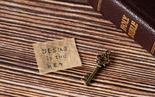 Jesus Christ Is The Key To Salvation And The Kingdom Of God. A Handwritten Quote On Old Paper With Rustic, Ancient, Vintage Key With Closed Holy Bible Book On Wooden Table. Christian Biblical Concept.
