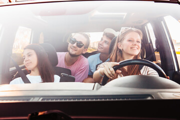 Wall Mural - four friends in car navigation on phone