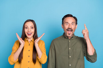 Poster - Photo of amazed cheerful mature man and woman point finger empty space sale isolated on blue color background