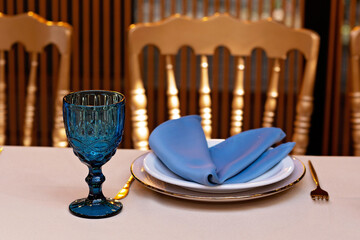 Wall Mural - Festive wedding, table setting with blue linen napkins, candles. Wedding decorations. Restaurant menu concept. Soft selective focus.