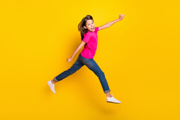 Poster - Photo of funky hurry sporty girl jump run fast rush side wear pink t-shirt jeans shoes isolated yellow color background