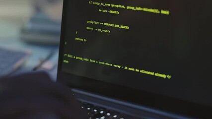 Close-up of unrecognizable programmer writing program codes on laptop at night